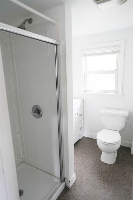 bathroom with vanity, toilet, and a shower with door