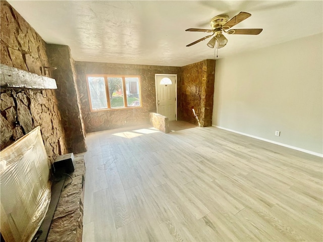 unfurnished living room featuring ceiling fan and light wood-type flooring