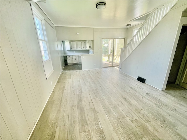 unfurnished living room featuring light wood-type flooring and a healthy amount of sunlight