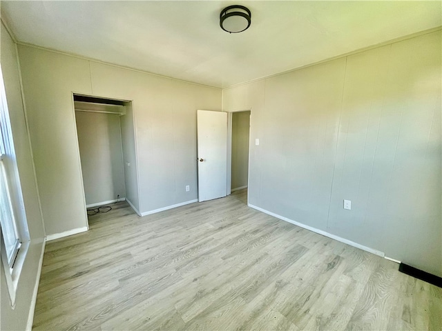 unfurnished bedroom with light hardwood / wood-style flooring and a closet