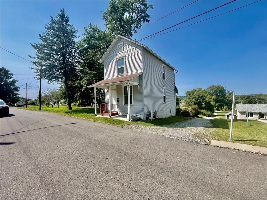 view of front of home with covered porch and a front yard