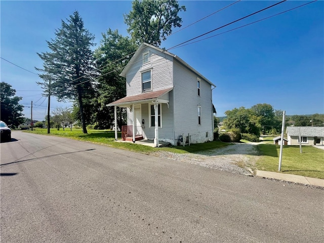 view of front of home with covered porch and a front yard