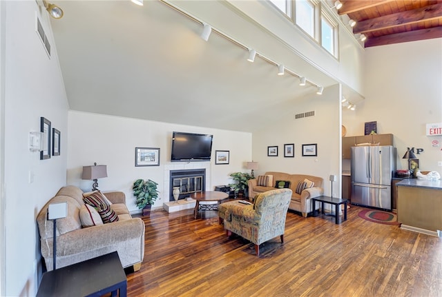 living room featuring a fireplace, beam ceiling, dark hardwood / wood-style flooring, and high vaulted ceiling