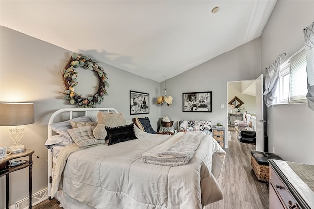 bedroom with lofted ceiling and hardwood / wood-style flooring