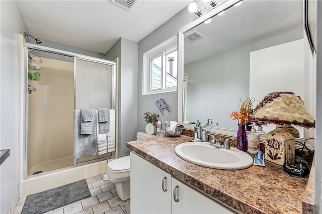 bathroom with tile patterned flooring, vanity, toilet, and a shower with door