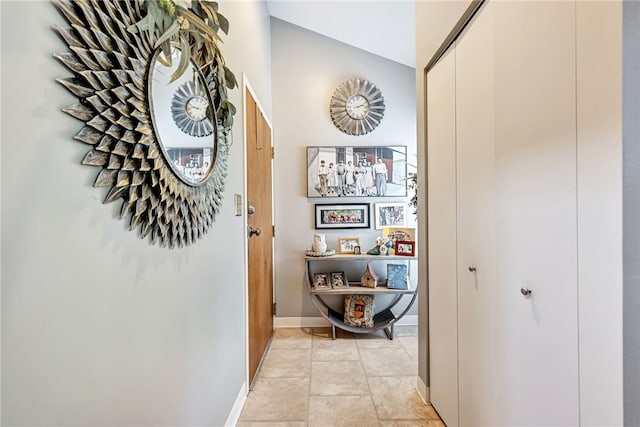 corridor featuring vaulted ceiling and light tile patterned floors