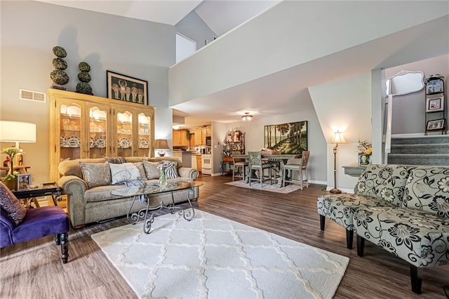 living room with wood-type flooring and high vaulted ceiling