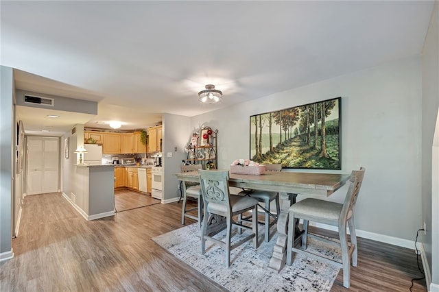 dining space with light hardwood / wood-style floors