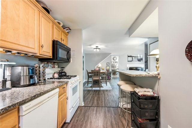 kitchen featuring light brown cabinetry, light stone countertops, white appliances, and dark hardwood / wood-style floors