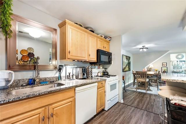 kitchen with dark wood-type flooring, light stone counters, white appliances, light brown cabinetry, and sink