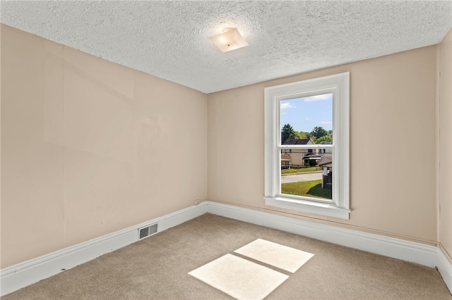 carpeted spare room with a textured ceiling