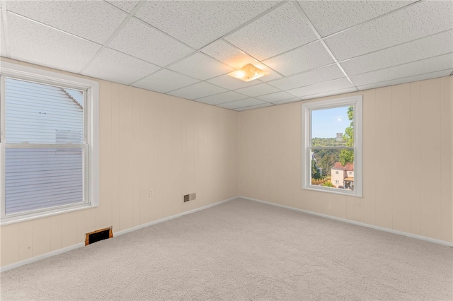 unfurnished room featuring carpet floors and a drop ceiling