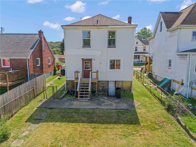 rear view of house with a lawn and a patio