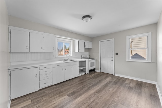 kitchen with electric stove, white cabinets, sink, and wood-type flooring