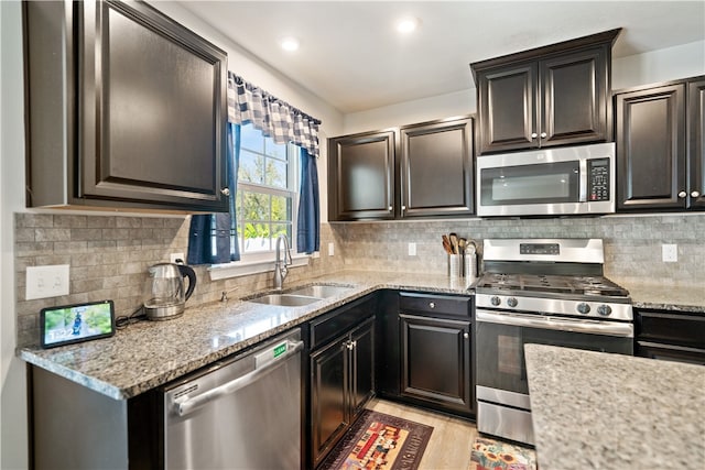 kitchen with decorative backsplash, stainless steel appliances, and light stone countertops