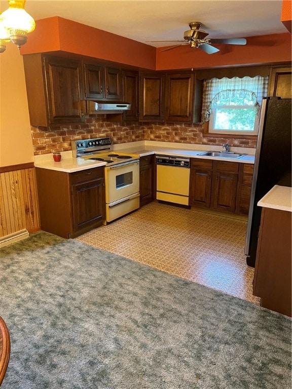 kitchen featuring white appliances, wood walls, exhaust hood, ceiling fan, and sink