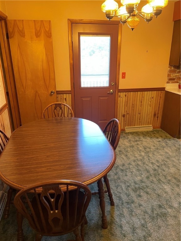 dining room with an inviting chandelier, wooden walls, and carpet