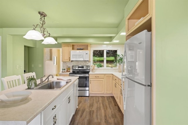 kitchen with hanging light fixtures, sink, dark hardwood / wood-style floors, backsplash, and white appliances