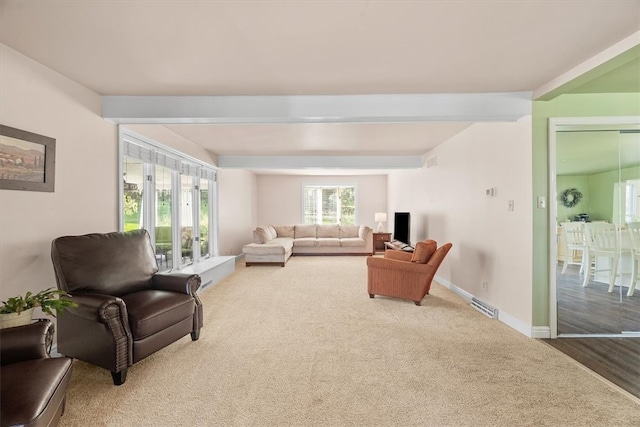 living room with carpet flooring, french doors, and beamed ceiling