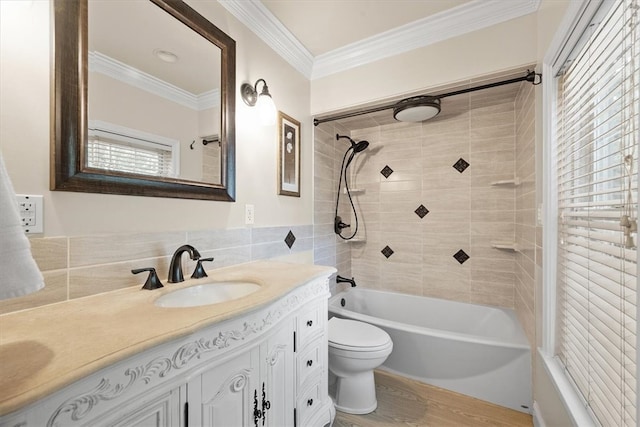 full bathroom featuring ornamental molding, vanity, hardwood / wood-style floors, toilet, and tiled shower / bath