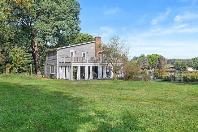 back of house with a wooden deck and a yard