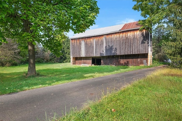 view of home's exterior featuring a lawn and an outdoor structure