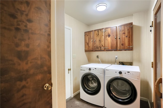 clothes washing area featuring cabinets and washer and dryer