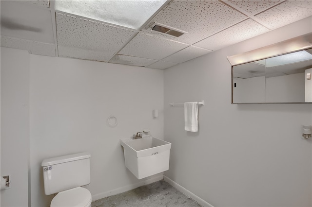 bathroom featuring a paneled ceiling and toilet