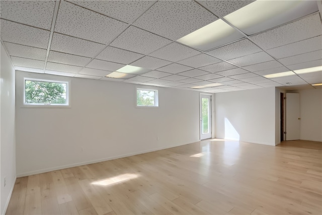 basement featuring light hardwood / wood-style flooring and a drop ceiling