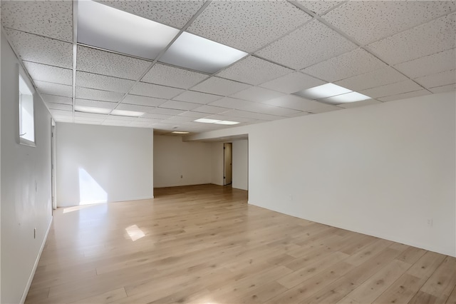 interior space featuring a paneled ceiling and light hardwood / wood-style floors