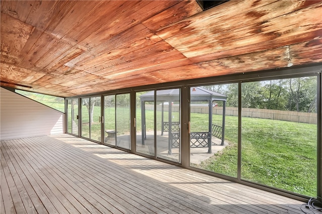 unfurnished sunroom featuring wood ceiling and plenty of natural light