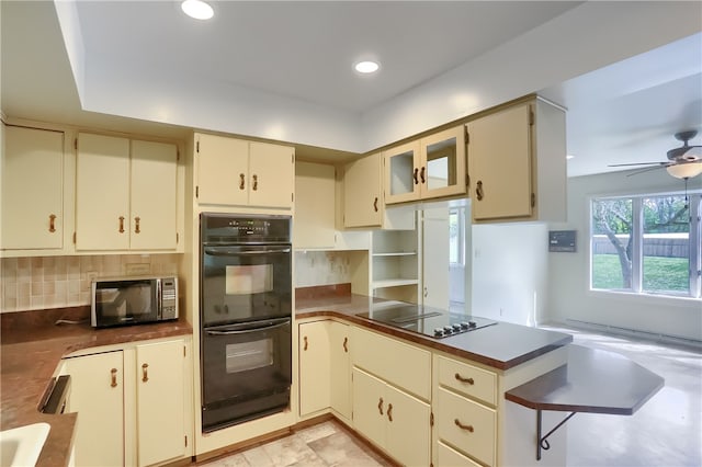 kitchen with black appliances, backsplash, cream cabinets, and ceiling fan