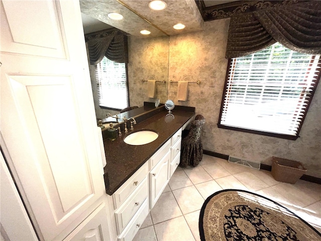 bathroom with a healthy amount of sunlight, tile patterned floors, and vanity