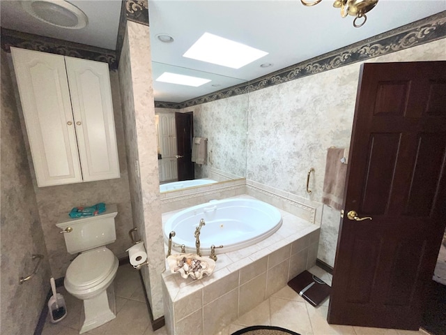 bathroom with tiled tub, toilet, and tile patterned flooring