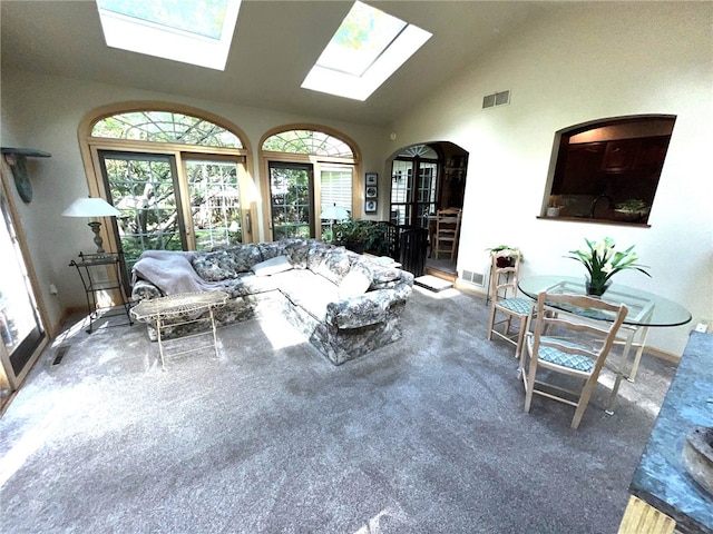 carpeted living room featuring vaulted ceiling with skylight