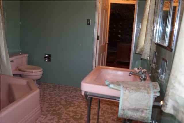 bathroom featuring a bath, vanity, and toilet