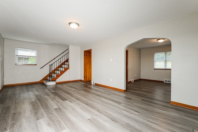 unfurnished living room featuring a healthy amount of sunlight and wood-type flooring