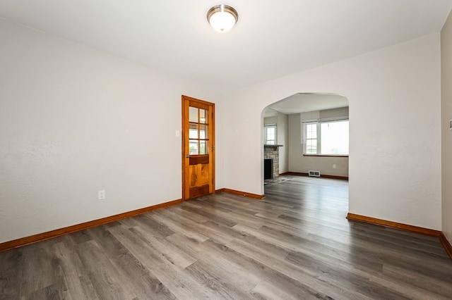 empty room featuring wood-type flooring and a fireplace