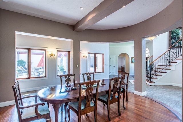 dining space featuring beam ceiling and hardwood / wood-style flooring