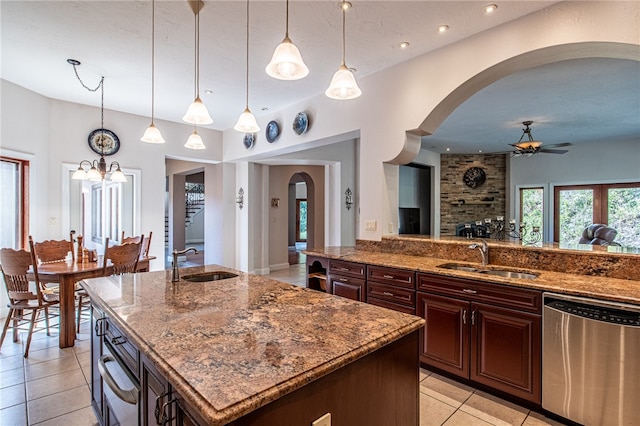 kitchen featuring dishwasher, sink, an island with sink, decorative light fixtures, and ceiling fan