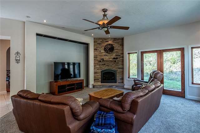 living room featuring ceiling fan, light colored carpet, a fireplace, and a wealth of natural light