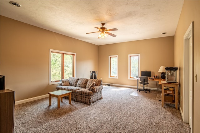 carpeted living room featuring a textured ceiling and ceiling fan