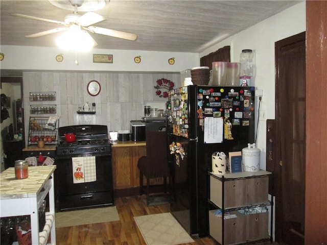 kitchen with black appliances, ceiling fan, and dark hardwood / wood-style floors