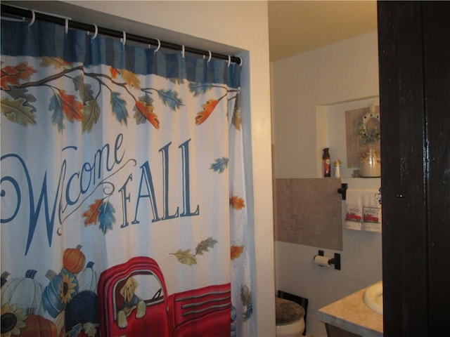 bathroom featuring walk in shower, vanity, and toilet