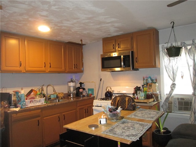 kitchen with a textured ceiling, cooling unit, a kitchen island, and sink