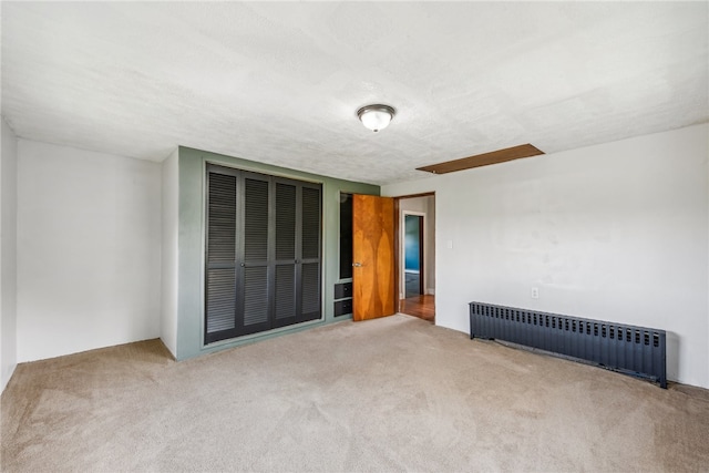 carpeted spare room with radiator and a textured ceiling