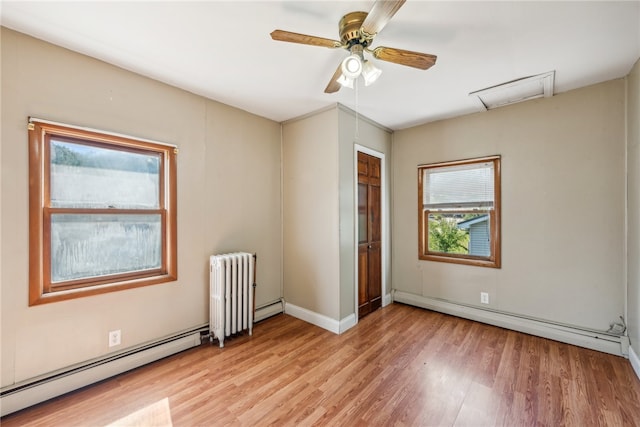 unfurnished room with radiator heating unit, ceiling fan, a baseboard heating unit, and light wood-type flooring