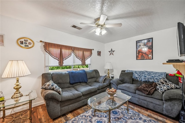 living room featuring dark wood-type flooring and ceiling fan