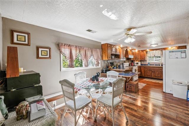 dining area with a wealth of natural light, hardwood / wood-style floors, and ceiling fan