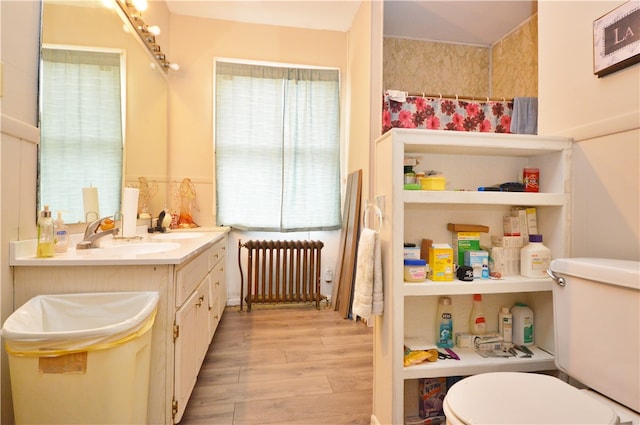 bathroom featuring vanity, hardwood / wood-style floors, toilet, and radiator heating unit